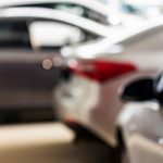 New,cars,at,dealer,showroom,blurred,background