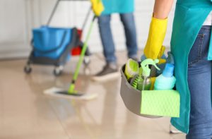 Female,janitor,with,cleaning,supplies,in,kitchen