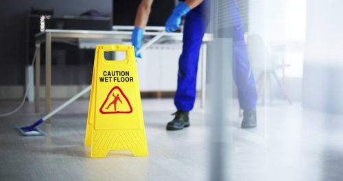 Low,section,of,male,janitor,cleaning,floor,with,caution,wet